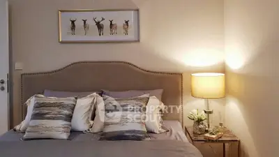 Elegant bedroom with stylish decor and cozy lighting, featuring a plush bed and modern artwork.