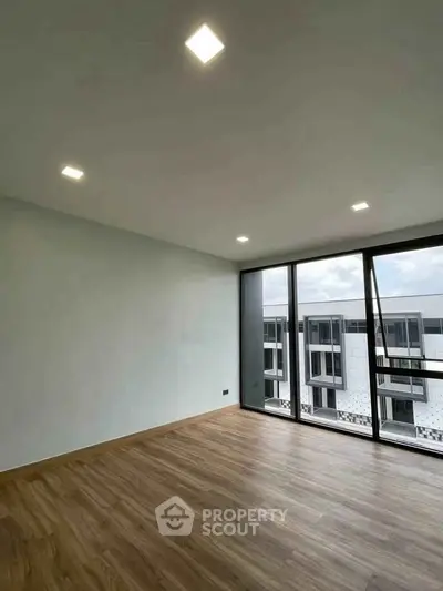 Spacious modern living room with large windows and wooden flooring
