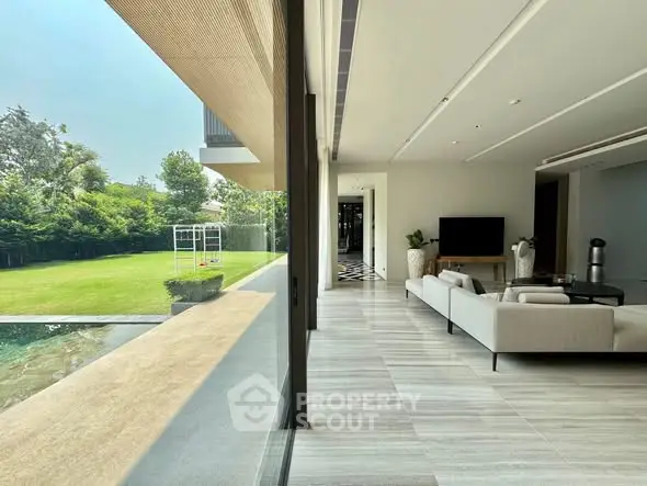 Luxurious living room with pool view and modern decor in a spacious open layout.