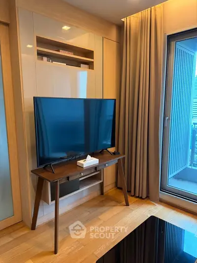 Modern living room with sleek TV setup and balcony access