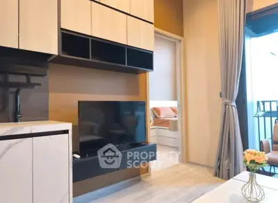 Modern living room with sleek TV unit and view into cozy bedroom, featuring elegant decor and natural light.