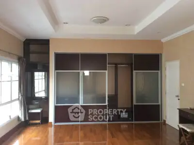 Spacious bedroom with elegant wooden flooring and large built-in wardrobe