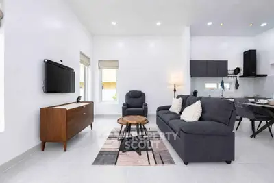 Modern living room with sleek furniture and open kitchen layout