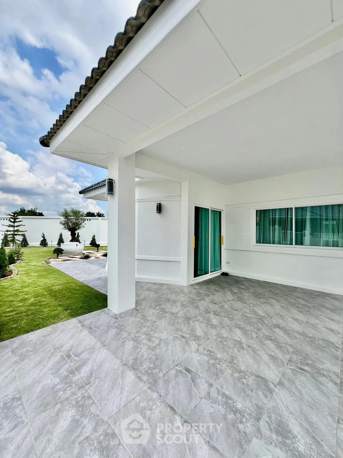 Spacious modern patio with tiled flooring and lush green garden view