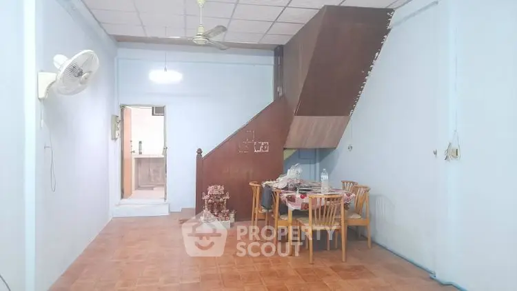 Spacious living area with dining set and staircase in cozy home