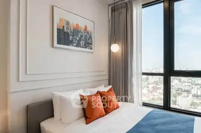 Modern bedroom with large window offering stunning city view and stylish decor.