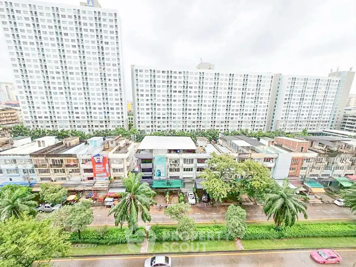 High-rise residential buildings with lush greenery and street view