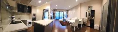 Spacious modern living room with open kitchen and large windows in luxury apartment.