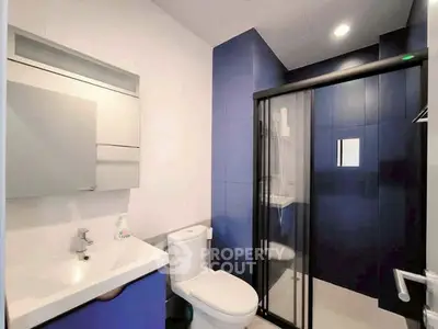 Modern bathroom with sleek blue accents and glass shower enclosure