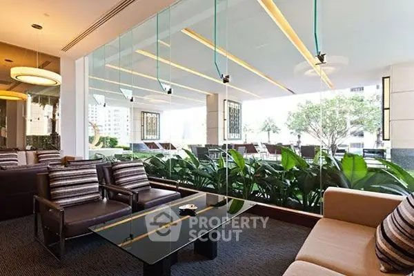 Luxurious modern living room with glass walls and lush greenery view