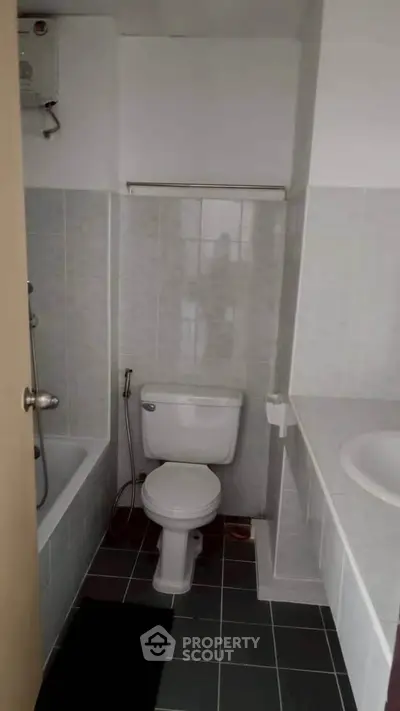 Compact bathroom with bathtub and modern fixtures in a cozy apartment.