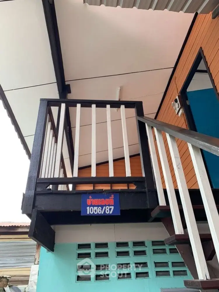 Modern exterior staircase with sleek railing design and vibrant color accents.