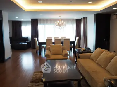 Spacious living room with elegant chandelier and dining area in modern apartment