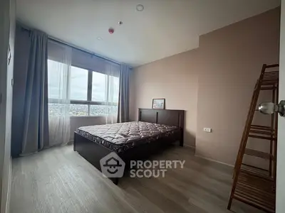 Spacious bedroom with large window offering stunning city views.