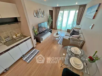 Modern living room with open kitchen, stylish decor, and balcony access in a cozy apartment.