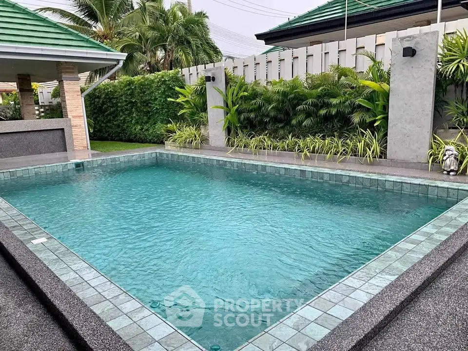 Luxurious private pool with lush greenery and modern design in a serene backyard setting.