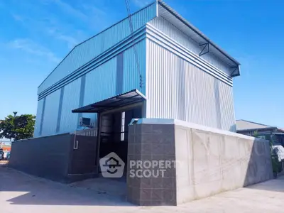 Modern industrial warehouse with sleek metal exterior and spacious entrance.