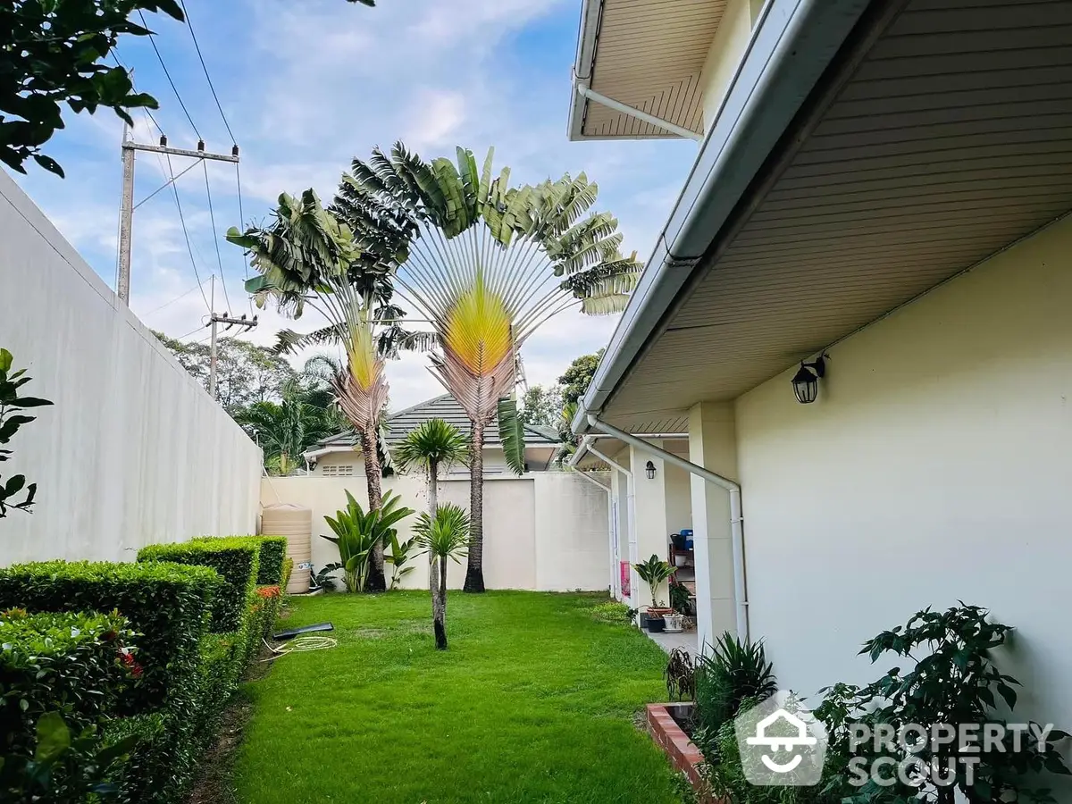 Lush green garden with vibrant tropical plants enhancing the serene outdoor space of a modern home, perfect for relaxation and entertainment.