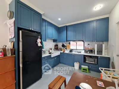 Charming kitchen with blue cabinets and modern appliances, featuring a cozy open layout and gas stove.
