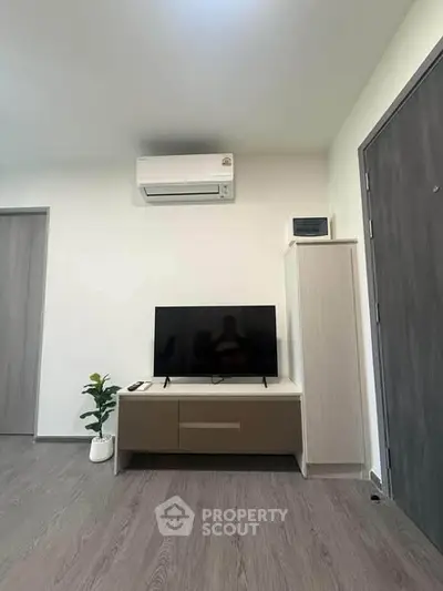Modern living room with sleek TV setup and air conditioning unit