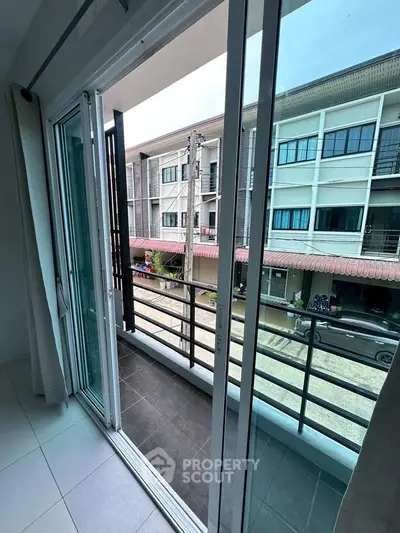 Modern balcony view with sliding glass doors and urban street scene