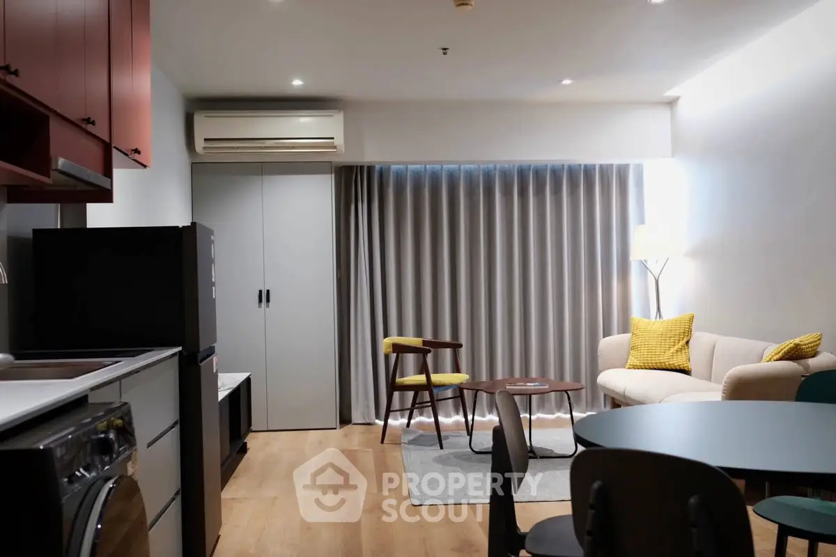 Modern living room with stylish furniture and open kitchen layout in a cozy apartment.