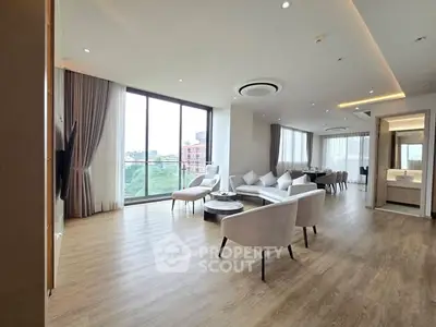 Spacious modern living room with large windows and elegant furnishings, offering a stunning city view.