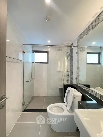Modern bathroom with glass shower and sleek fixtures in a contemporary home.