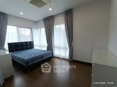 Spacious bedroom with large windows and modern furnishings