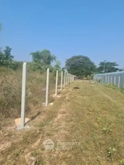 Expansive land plot with clear blue sky, ideal for development opportunities.