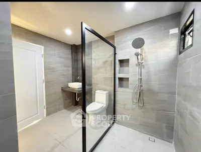 Modern bathroom with glass shower enclosure and sleek fixtures