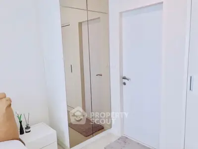 Modern bedroom with mirrored wardrobe and sleek white door