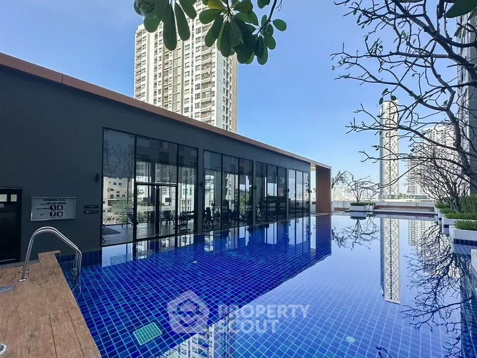 Luxurious rooftop pool with stunning city views in modern high-rise building.