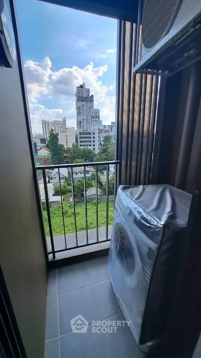 Compact balcony with city view and washing machine, perfect for urban living.