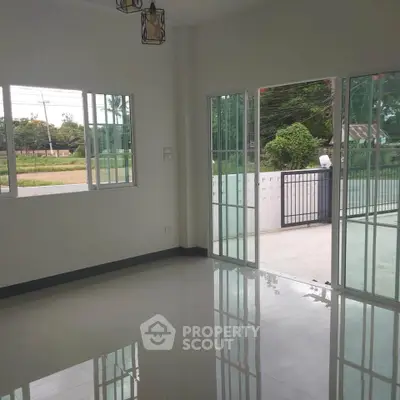 Spacious living room with large windows and sliding doors to garden view.
