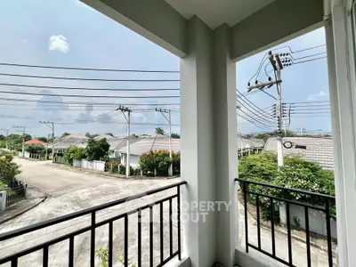 Charming suburban view from a balcony overlooking a quiet residential street.