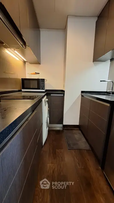 Modern kitchen with sleek cabinetry and built-in appliances in a compact layout.