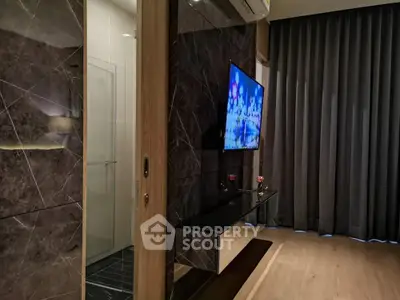 Modern living room with sleek TV setup and elegant dark curtains