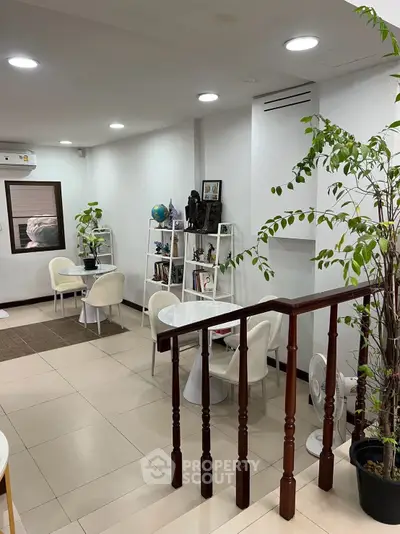 Modern living room with stylish decor and indoor plants, featuring a cozy seating area and elegant shelving.