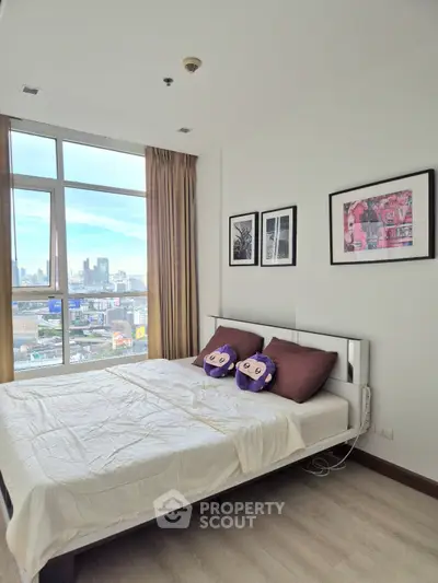 Spacious bedroom with city view and modern decor in high-rise apartment