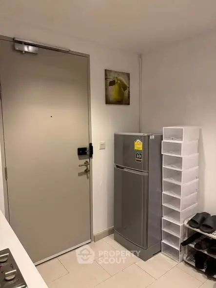 Compact kitchen area with modern fridge and storage solutions