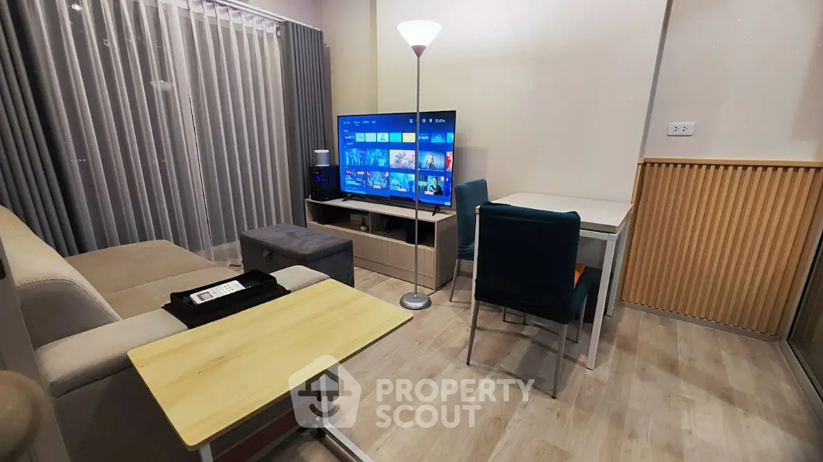 Modern living room with stylish decor, featuring a cozy sofa, flat-screen TV, and elegant lighting.