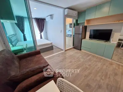 Modern apartment interior with open layout, featuring a cozy living room, bedroom, and kitchen area.