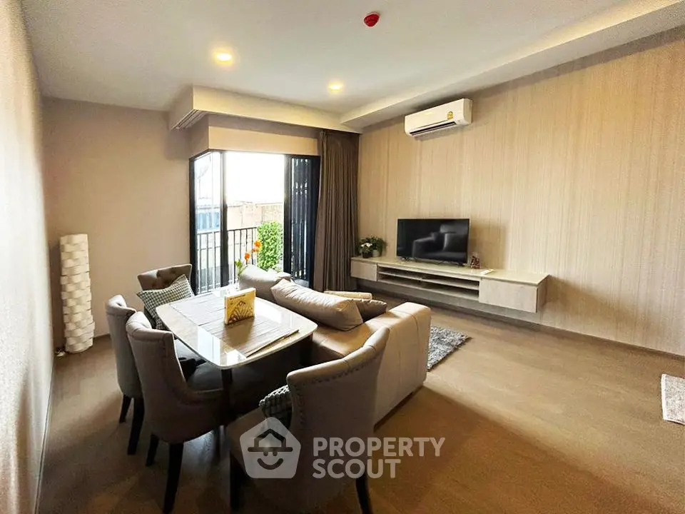 Modern living room with elegant dining area and wall-mounted TV, featuring stylish furniture and natural light.