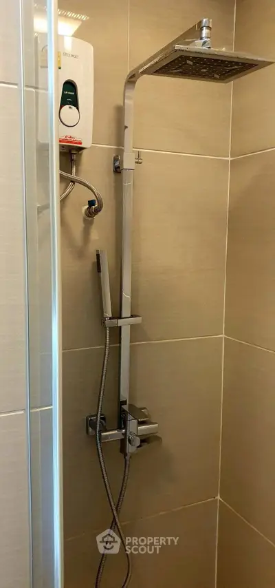 Modern bathroom shower with sleek fixtures and water heater in a tiled setting.