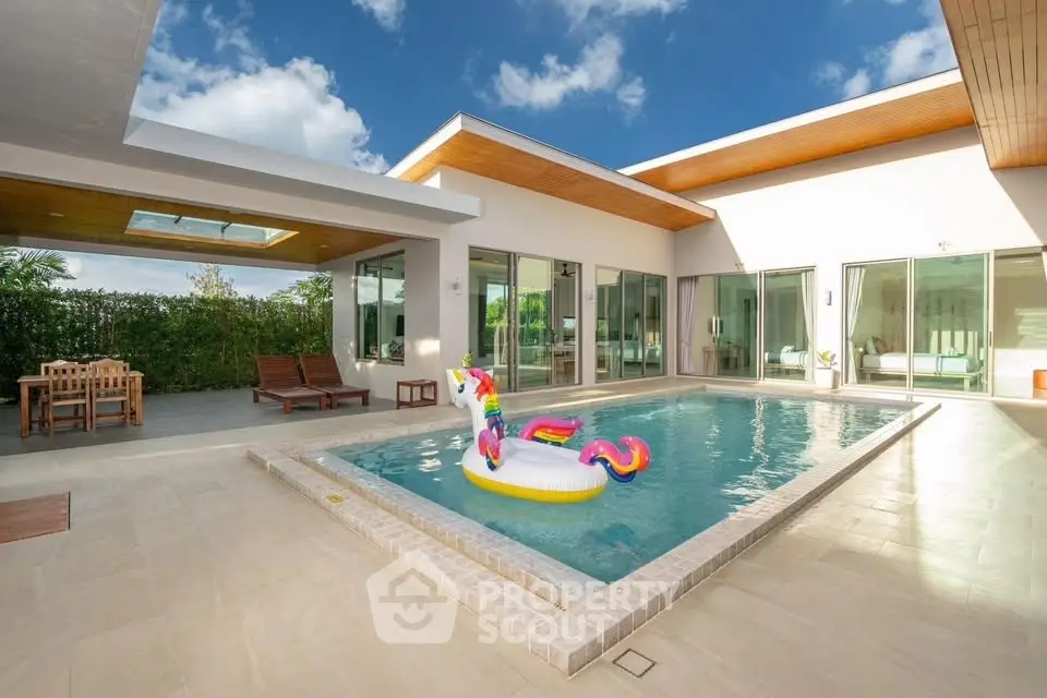 Luxurious modern villa with private pool and sunlit patio, perfect for relaxation and entertainment.