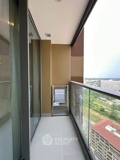 Modern balcony with glass railing and city view, perfect for relaxation.