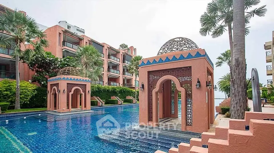 Luxurious Mediterranean-style pool area with ornate architecture and lush greenery.