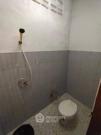 Compact bathroom with basic fixtures and tiled walls, ideal for small spaces.