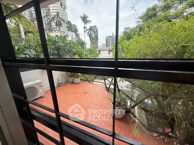 Spacious balcony with lush greenery and city view, perfect for relaxation and outdoor enjoyment.